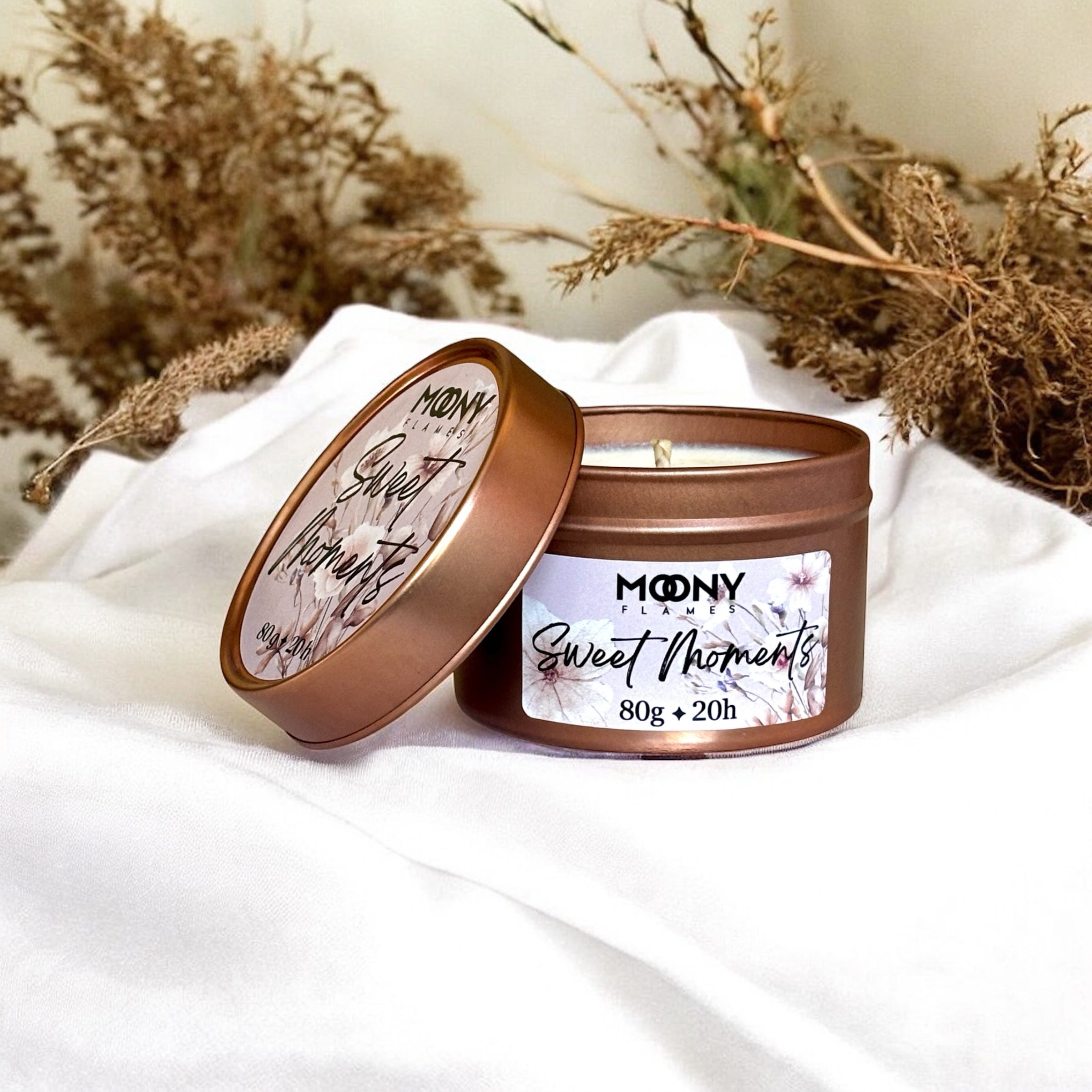 Doftljus Sweet Moments i roseguld metallburk på en vit duk. Reseljus - Moony Flames