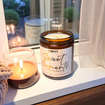 Handgjort doftljus från Moony Flames framför vardagsrumsfönstret.