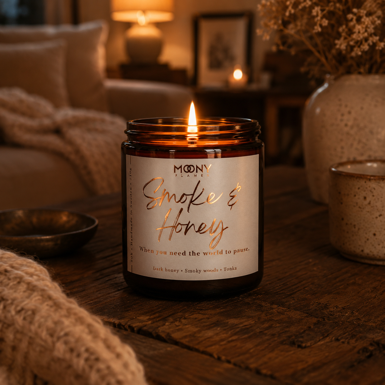 Höstdoftljus Smoke and Honey i ett varmt och mysigt vardagsrum med varm kvällsbelysning. 