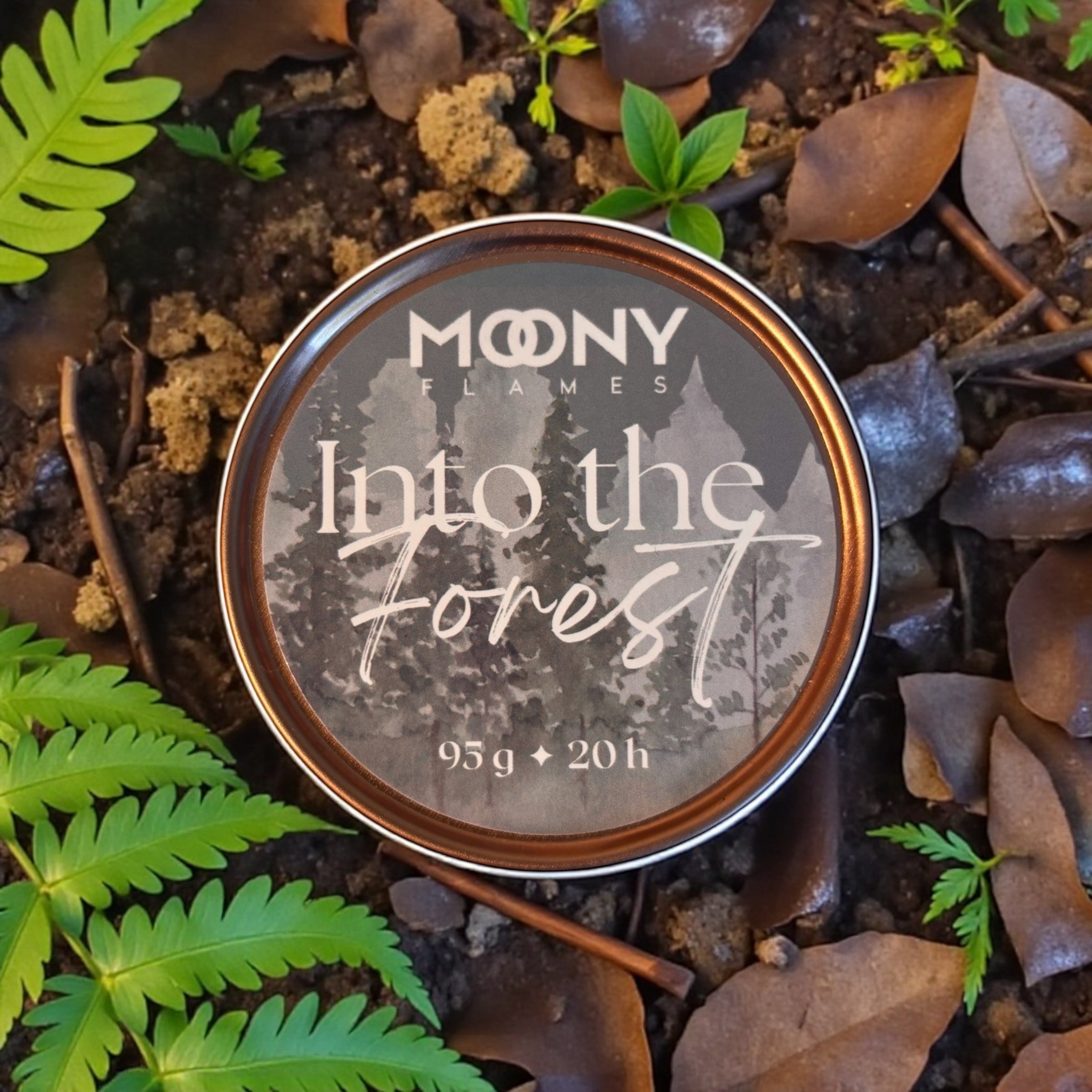 Doftljus Into the Forest i metallburk som visas uppifrån ute i skogen. 