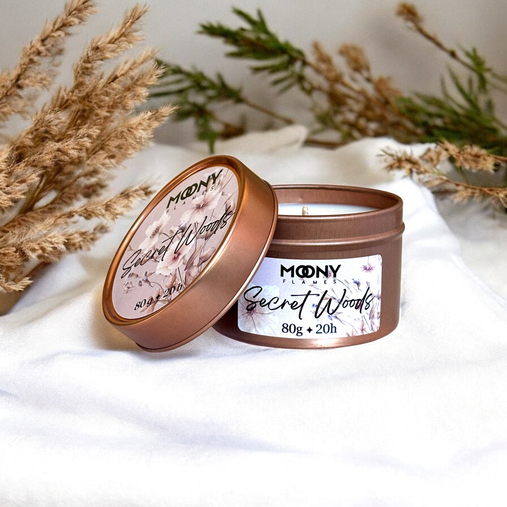 Doftljus Secret Woods i roseguld metallburk på en vit duk. Reseljus - Moony Flames