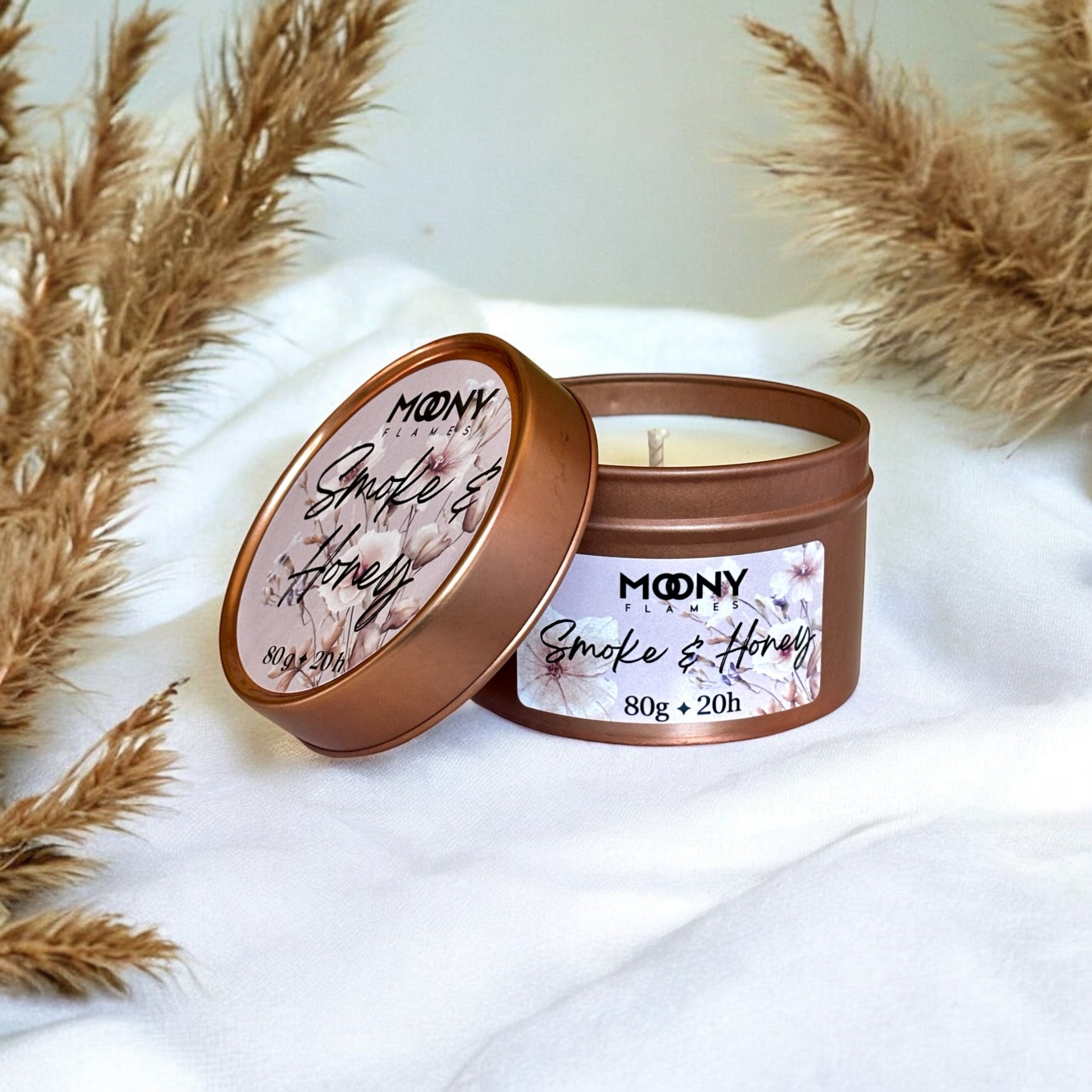 Doftljus Smoke & Honey i roseguld metallburk på en vit duk. Reseljus - Moony Flames