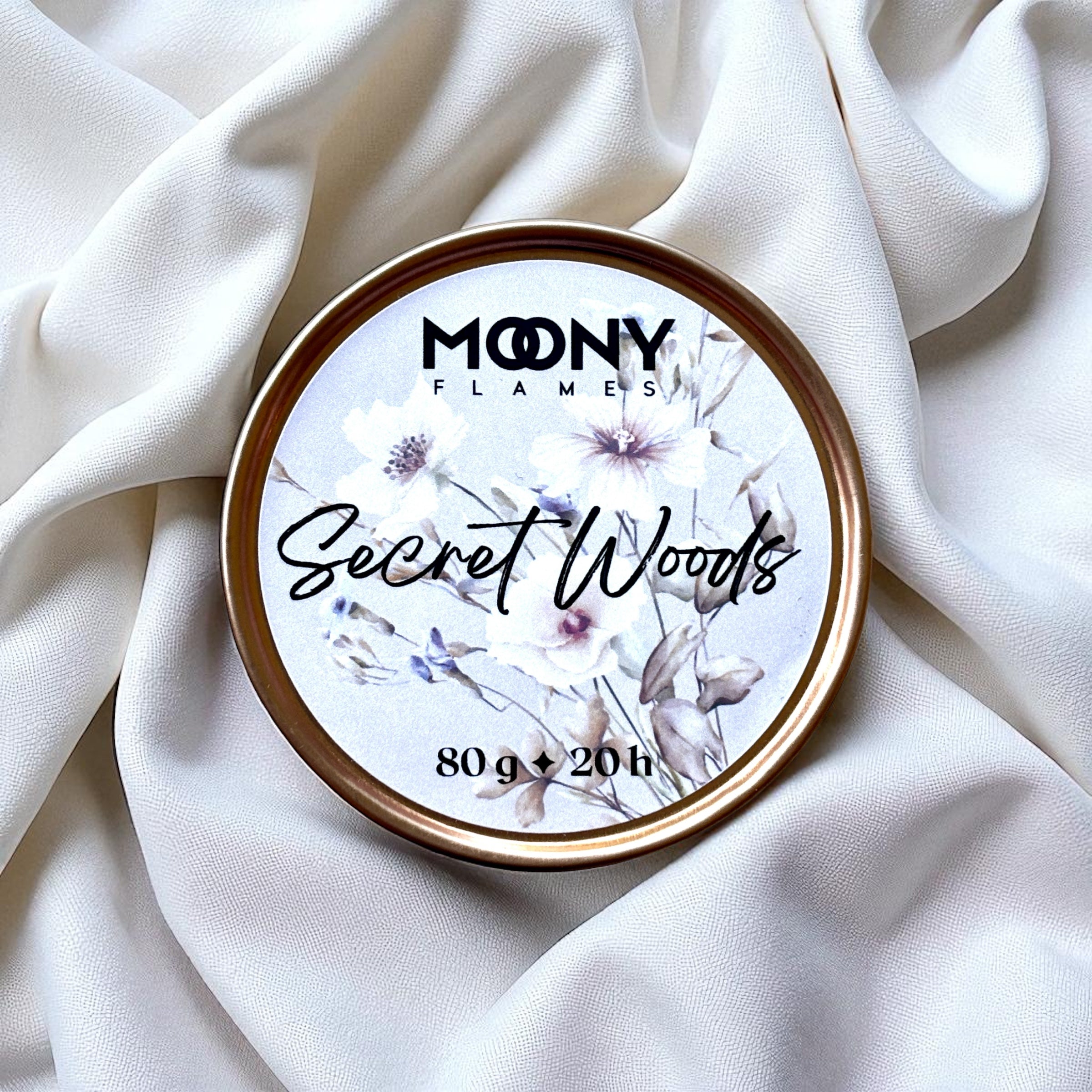 Doftljus Secret Woods i roséfärgad metallburk på en vit duk - Moony Flames