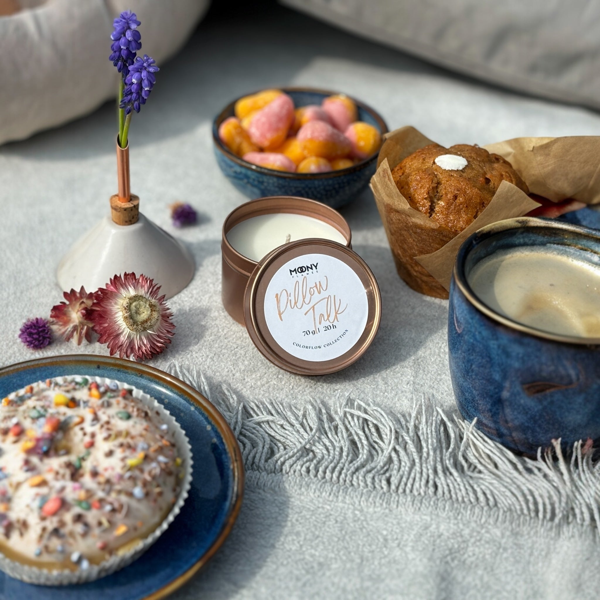 Handgjort doftljus Pillow Talk i metallburk på picknickfilt.