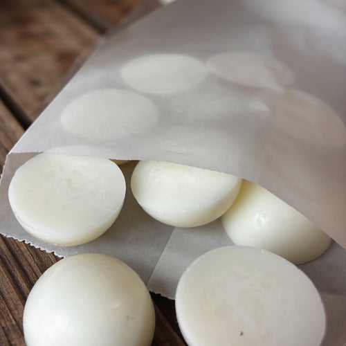 Moony Flames doftpraliner i papperspåse som ligger öppen på ett rustikt träbord. Ngra doftpraliner har rullat ut den halvöppna påsen.