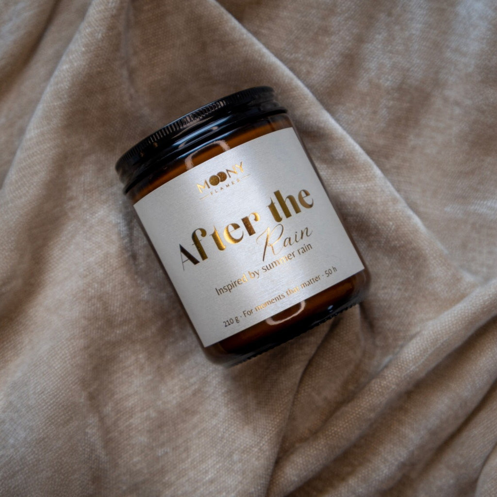 Handgjort doftljus After the Rain i brun glasburk på mjukt tyg – inspirerat av sommarregn och petrichor.