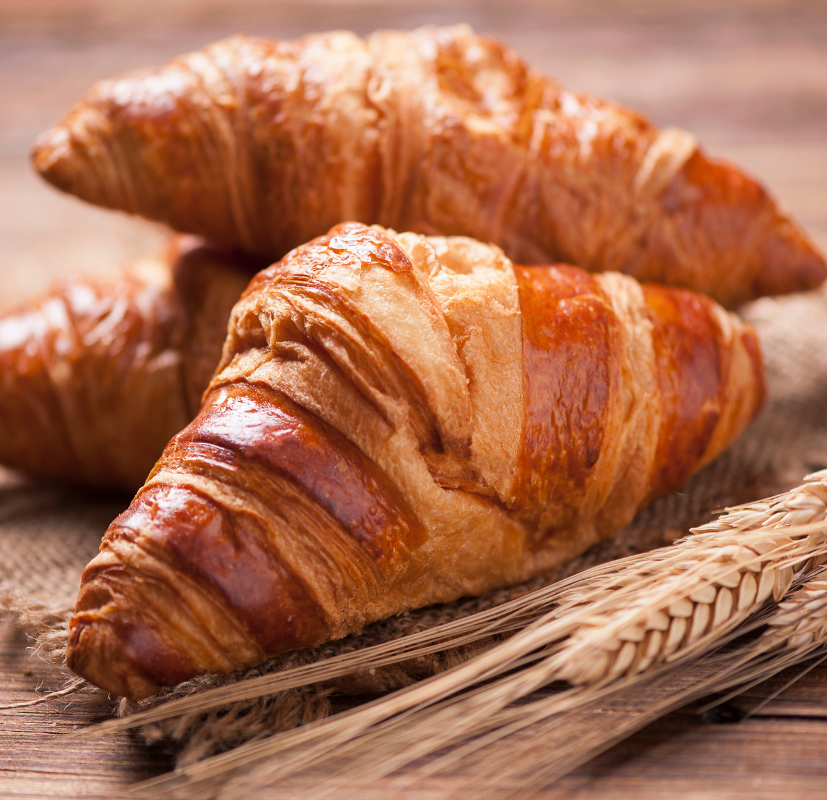 Nybakade gyllene croissanter som illustrerar den smöriga och vaniljsöta doften i doftljuset Croissant Love från Moony Flames.