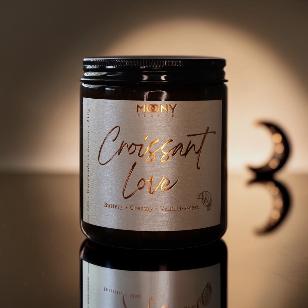 Croissant Love är ett handgjort doftljus från Moony Flames, inspirerat av långsamma morgnar med nybakade croissanter, smöriga bakverk och den första koppen kaffe.