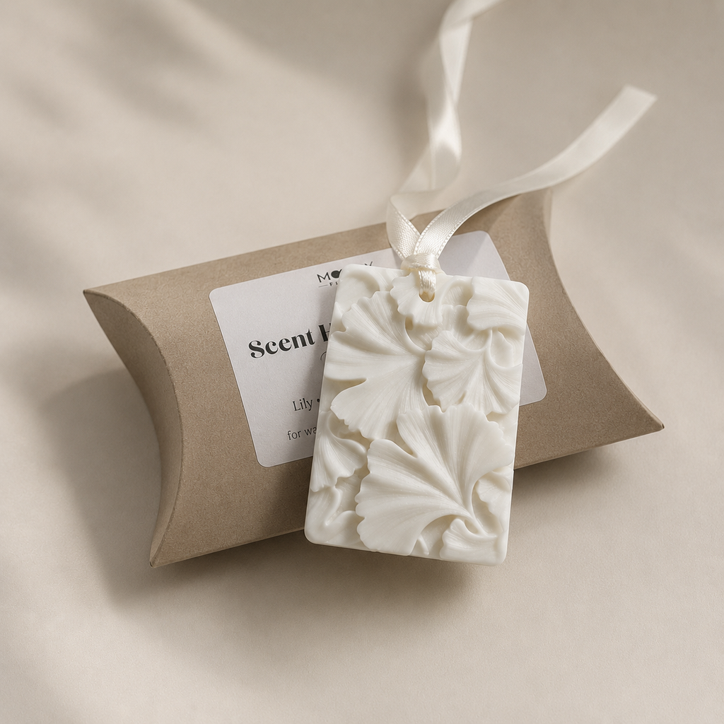 Vit dofthängare från Moony Flames med dekorativt blommönster och satinband. Handgjord i Småland, Sverige och presenterad tillsammans med elegant presentförpackning för garderob, byrå eller mindre utrymmen.
