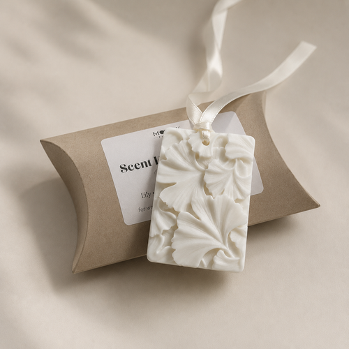 Vit dofthängare från Moony Flames med dekorativt blommönster och satinband. Handgjord i Småland, Sverige och presenterad tillsammans med elegant presentförpackning för garderob, byrå eller mindre utrymmen.