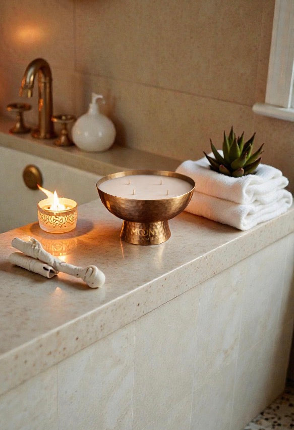 Golden Ritual doftljus från Moony Flames i hamrad mässingsskål, placerat i ett lugnt badrum med handdukar och varmt ljus för avkopplande ritualer och selfcare.