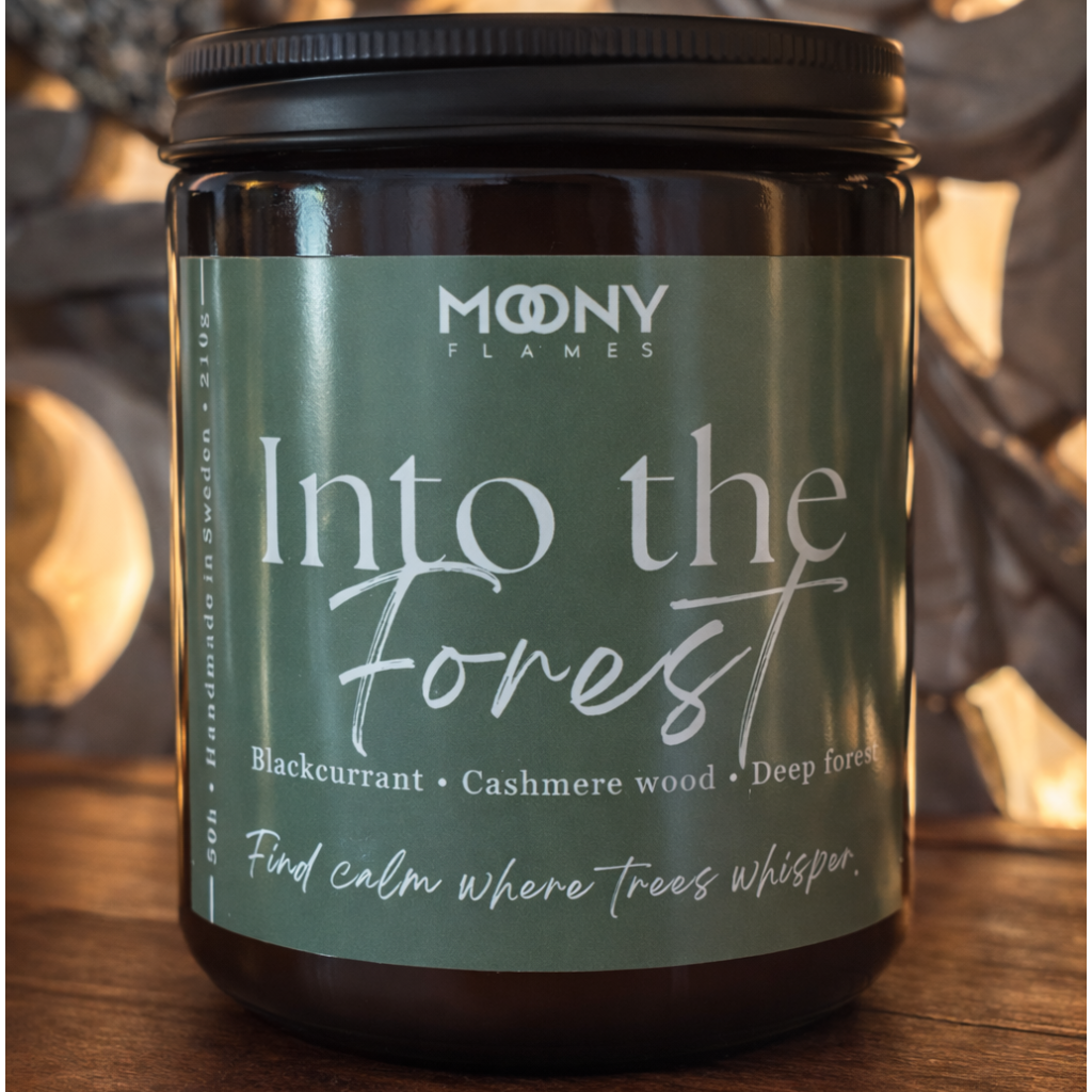 Into the Forest doftljus från Moony Flames – ett grönt, rogivande doftljus med svarta vinbär, cashmere wood och djupa skogstoner.