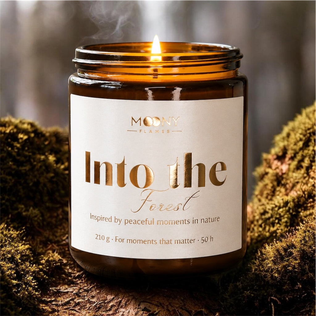 Tänt Into the Forest doftljus i amberglas från Moony Flames. Handgjort doftljus med frisk skogsdoft, tall, ekmossa och gröna noter inspirerade av naturen.