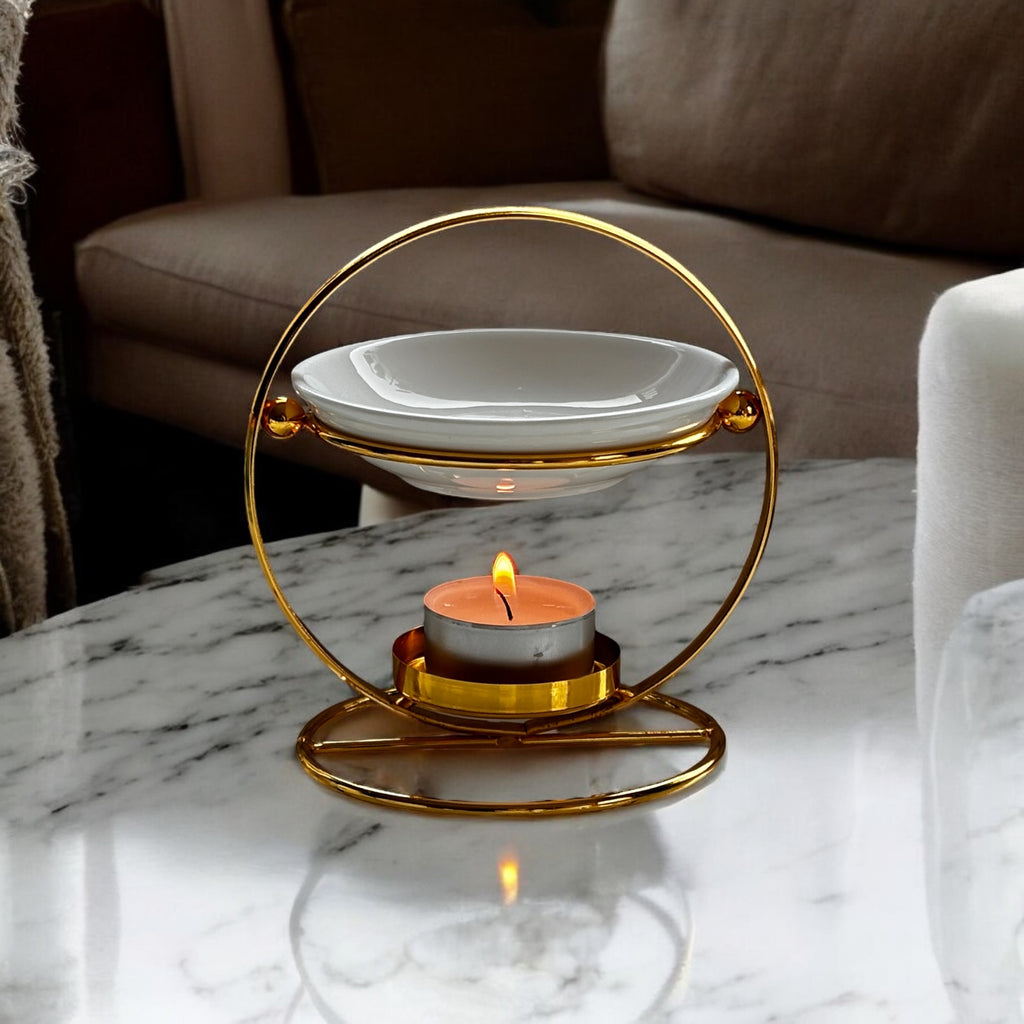 Lume aromalampa i guldmetall – elegant doftlampa för doftvax och eteriska oljor, med soffa.