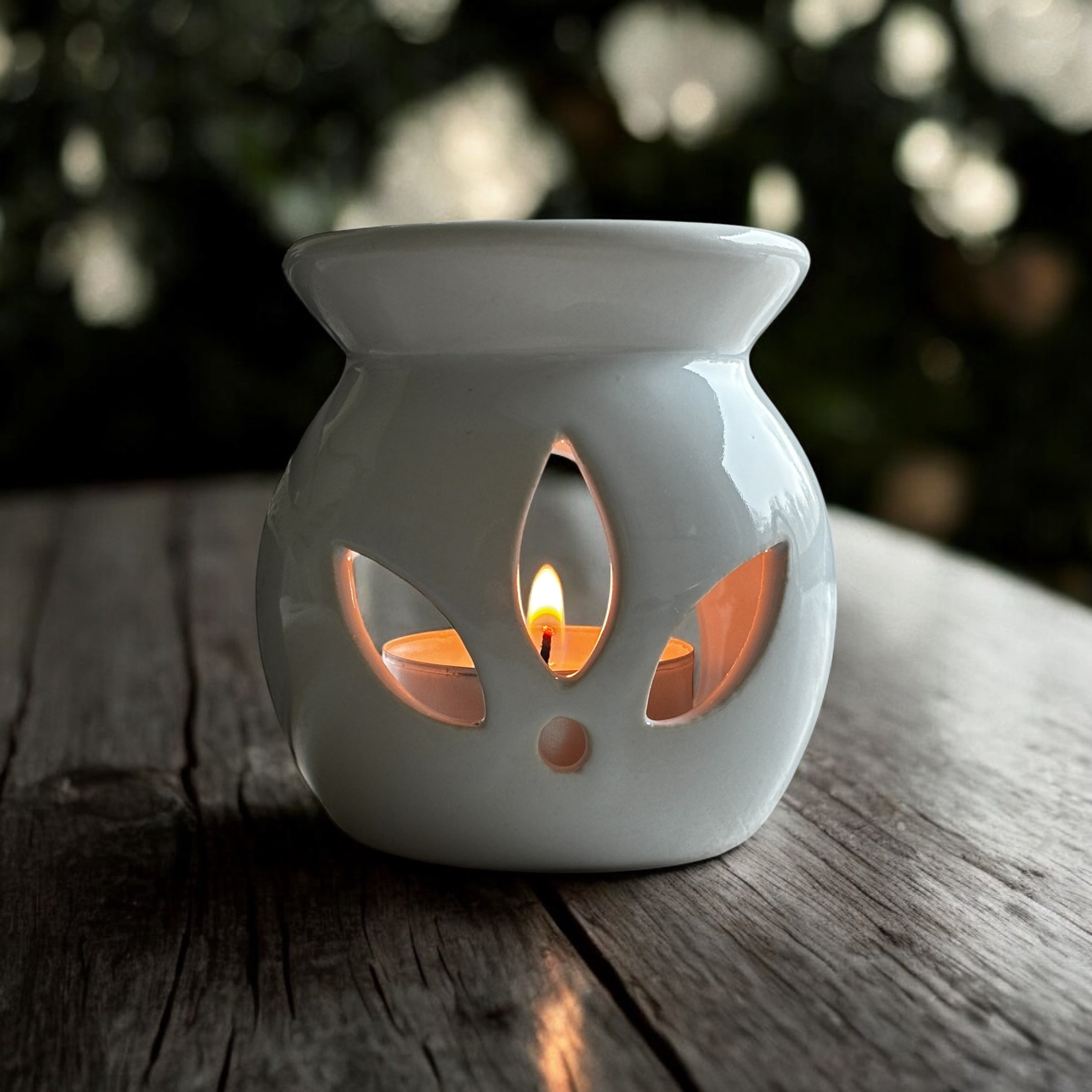 White Lotus aromalampa i vit keramik – liten och elegant doftlampa för doftvax och eteriska oljor som står på ett modernt träbord.