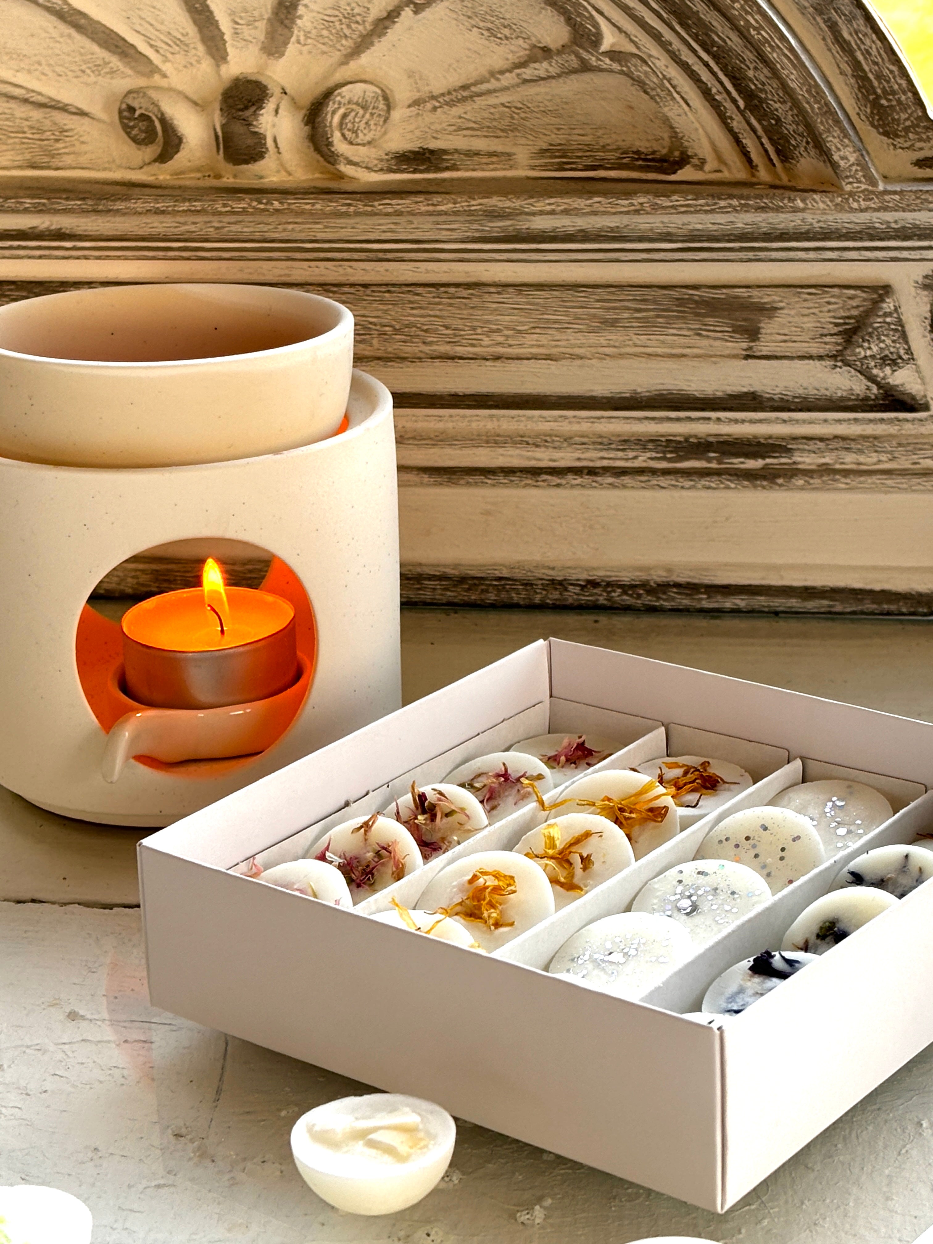 Handgjorda doftvaxer från The Scent Box, dekorerade med ekologiska blommor för en unik doftupplevelse, på skrivbord.