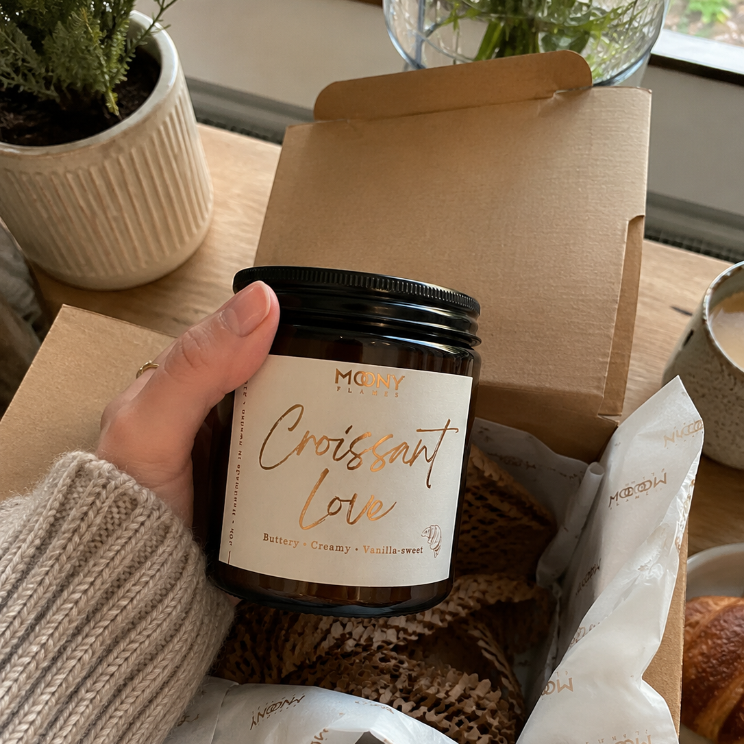 Croissant Love doftljuset från Moony Flames i öppnad presentförpackning hemma på köksbordet.