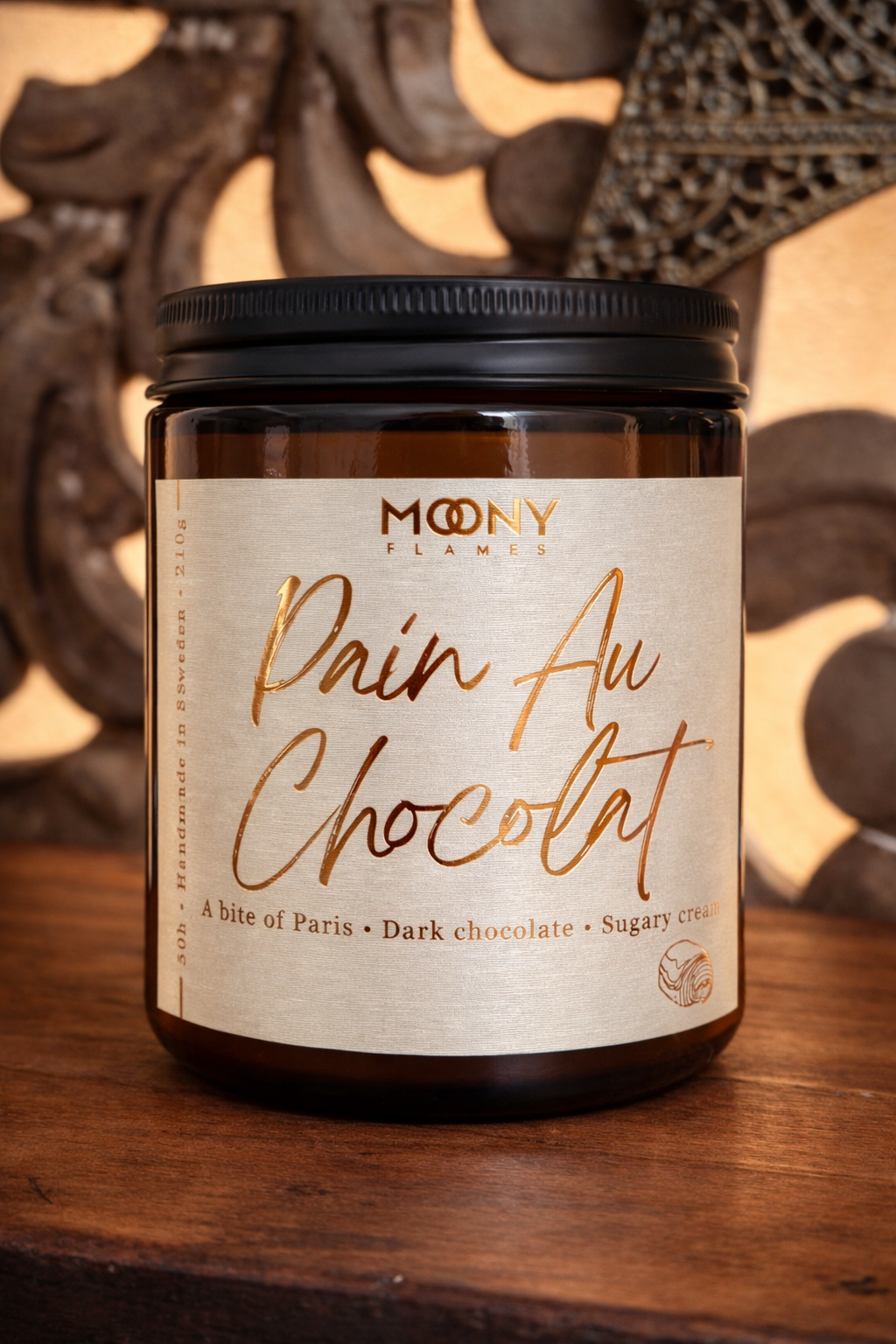 Pain Au Chocolat doftljus från Moony Flames – ett varmt och krämigt gourmand-doftljus med noter av mörk choklad och söt grädde, inspirerat av Paris.