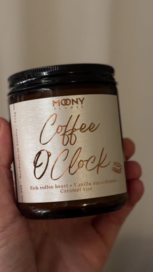 Video som visar doftljuset Coffee O’Clock med kaffedoft från Moony Flames i amberglas, med varm belysning och lugn, stämningsfull bakgrund.
