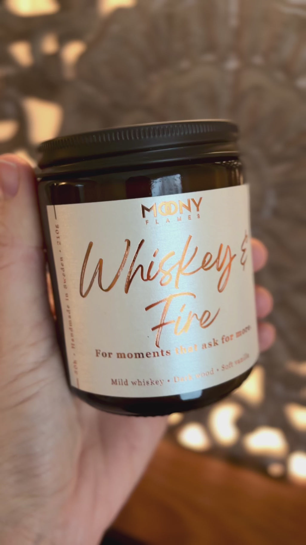 Video som visar doftljuset Whiskey & Fire från Moony Flames i varm, stämningsfull miljö med djupa, rökiga toner och levande låga.
