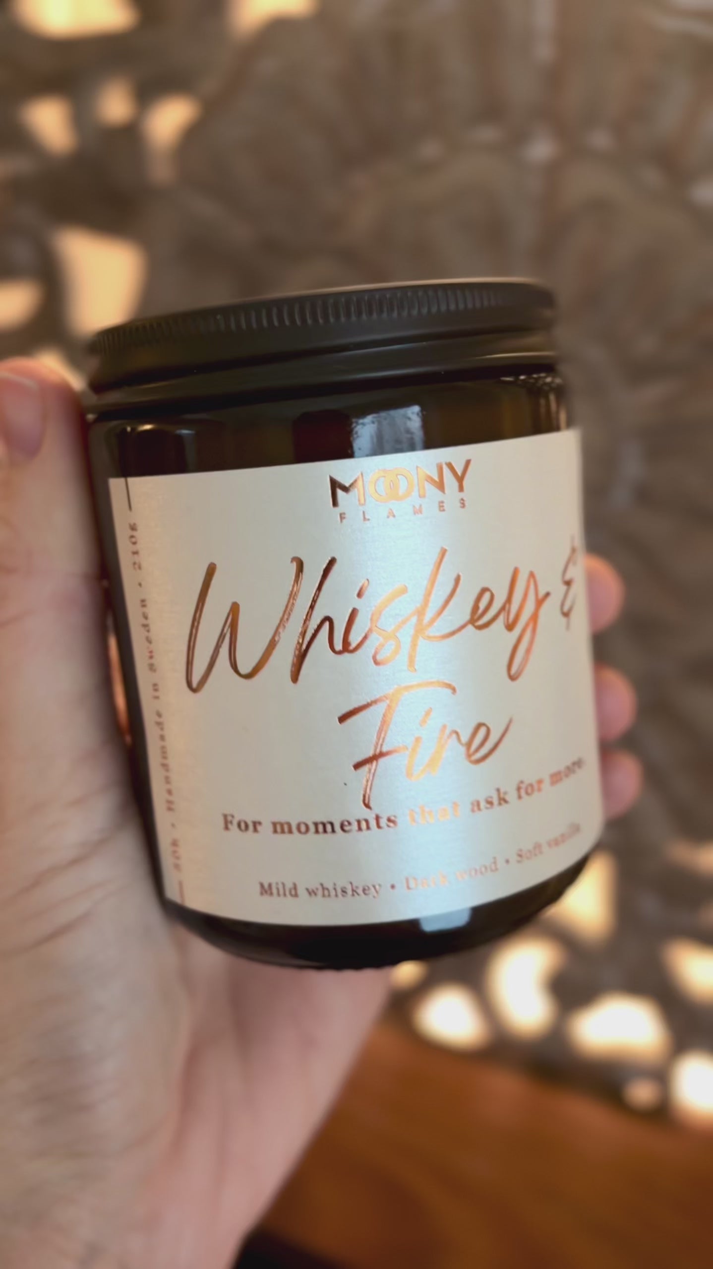 Video som visar doftljuset Whiskey & Fire från Moony Flames i varm, stämningsfull miljö med djupa, rökiga toner och levande låga.
