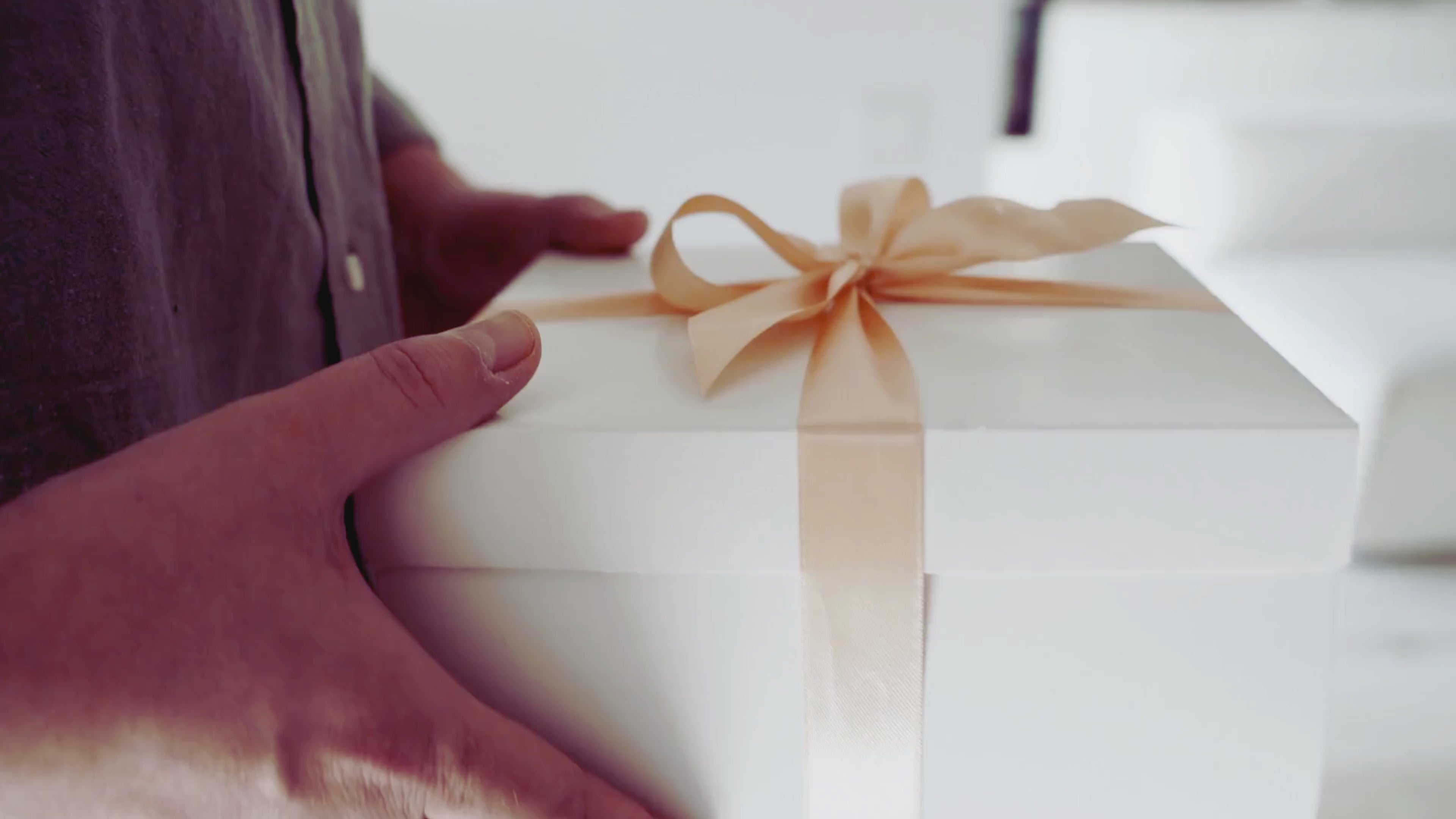 Person som bär in en present med Mystery Candle – handgjort doftljus från Sverige och en överraskningsgåva.