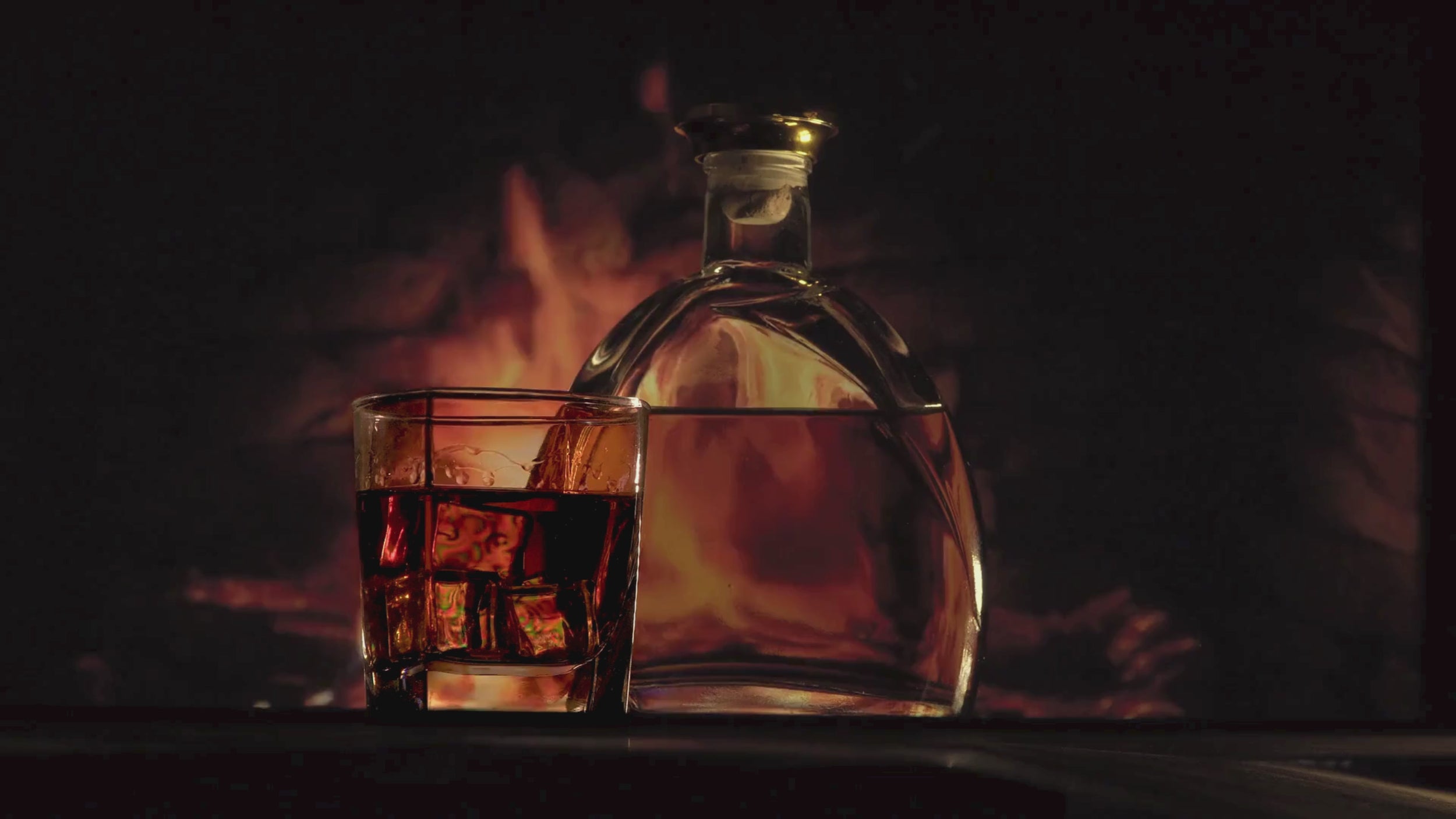 Stämningsvideo med kamineld och ett glas whiskey som visar känslan bakom doftljuset Whiskey & Fire från Moony Flames.