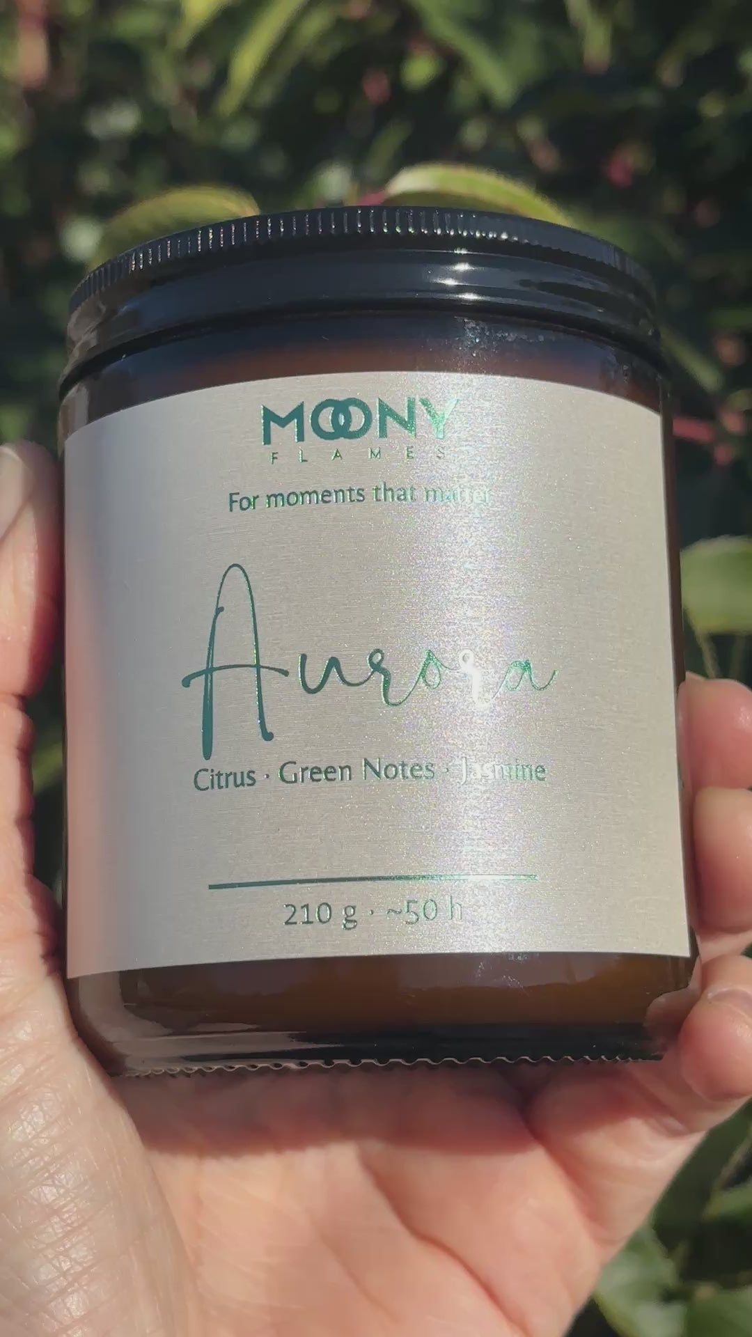 Handgjort doftljus från Moony Flames Sverige som doftar blommigt och grönt och som hålls i handen utomhus.