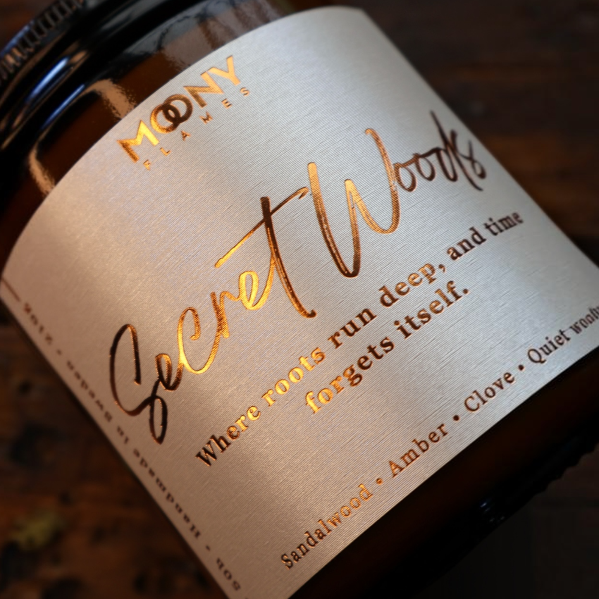 Närbild på Secret Woods doftljus från Moony Flames med sandelträ, cederträ och amber