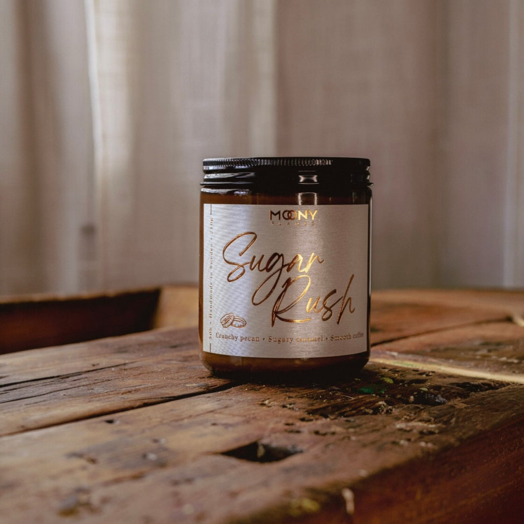 Handgjort doftljus från Sverige – Sugar Rush med söt och varm doft av karamell, pecan och kaffe, en ren produktbild på träbord