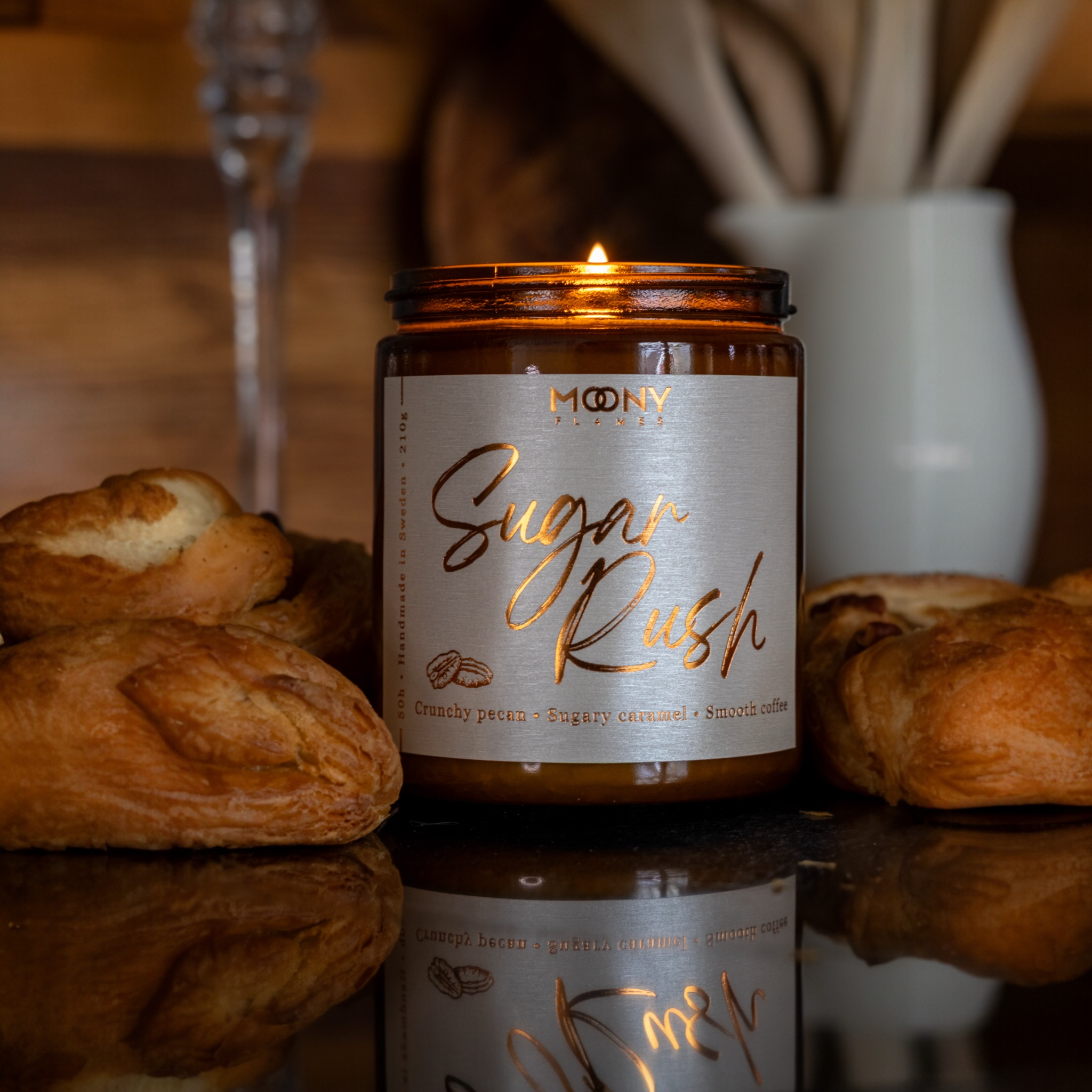 Handgjort doftljus från Sverige – Sugar Rush tänt ljus med söt och varm doft av karamell, pecan och kaffe, omgiven av bakverk för en mysig och inbjudande känsla