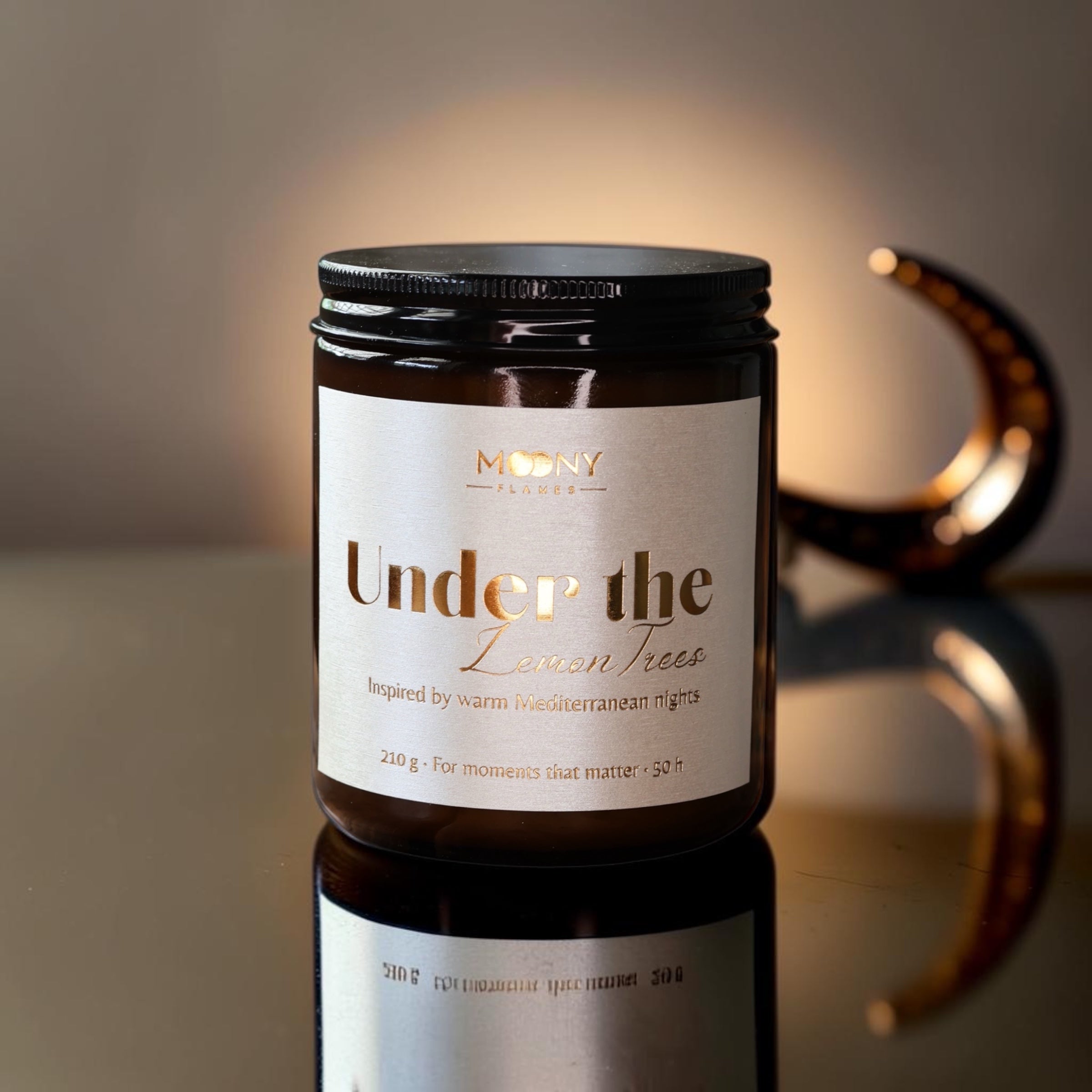 Handgjort doftljus Under the Lemon Trees från Moony Flames i brunt glas, tillverkat i Småland av 100 % svenskt sojavax med frisk doft av citron, apelsin och gröna tomatblad.