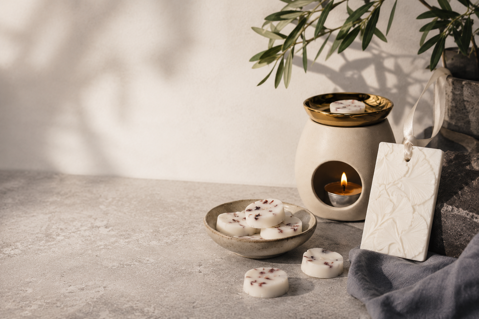 Handgjord aromalampa med doftvax och dofthängare i en modern, varm och naturlig miljö.